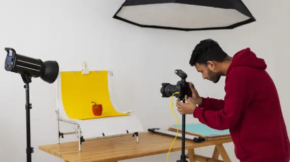 A photographer takes a picture of products inside a studio