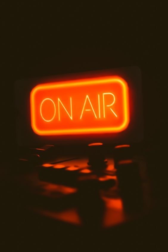 glowing red neon sign displaying the word “on air