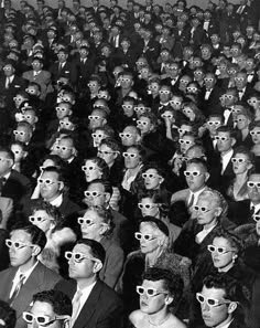 black and white photo of large theatre audience wearing 3d glasses