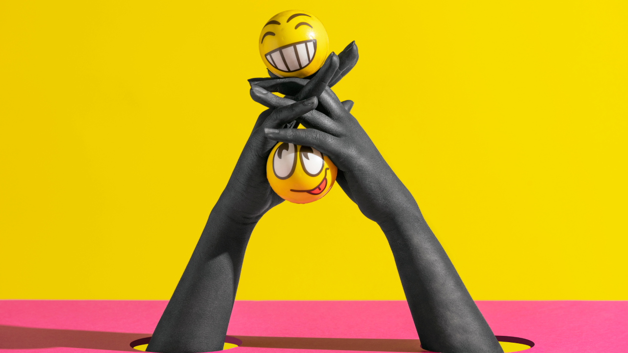 A concept image for unhinged marketing, showing two smiley stress balls with weird expressions being held by two hands