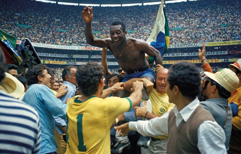 Brazilian footballer Pelé is lifted by celebrating fans inside a packed stadium, with a Brazilian flag visible behind him after a historic football victory in the 1970 World Cup 